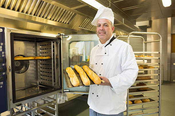 istock Mature baker showing three baguettes 510995593
