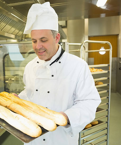 istock Mature head chef holding some baguettes 510995775