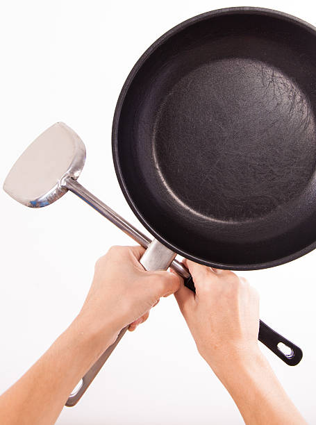 istock holding old saucepan and spatula with clipping path 510997619