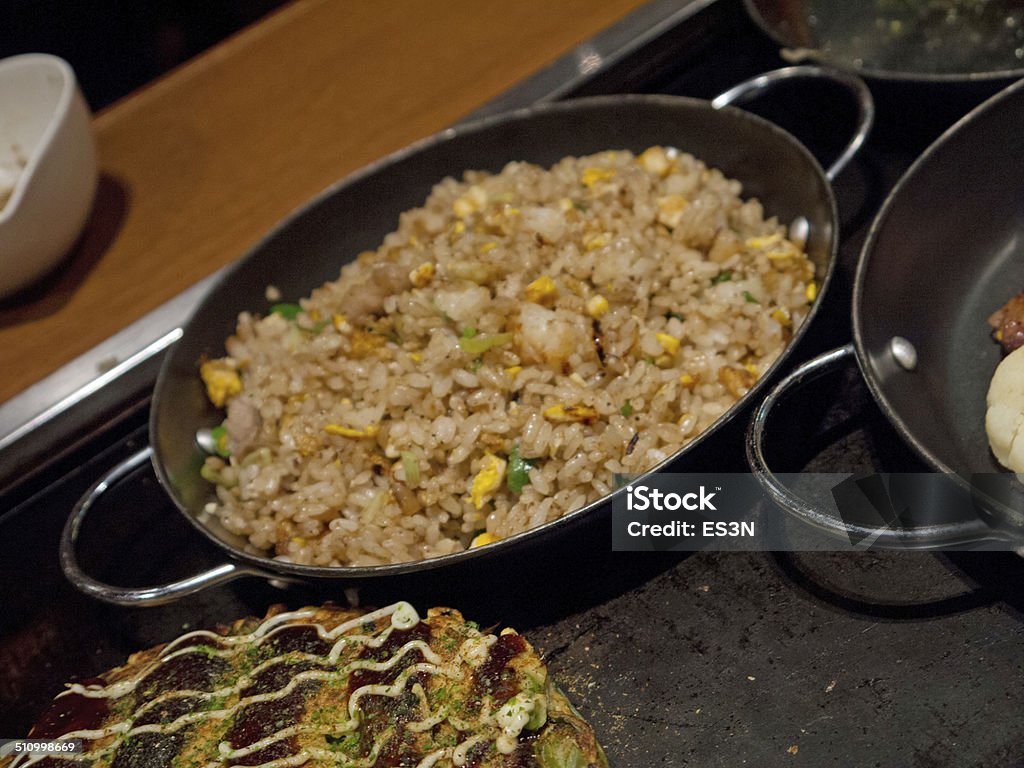 Fried rice and okonomiyaki Fried rice and okonomiyaki on teppan plate Cooking Stock Photo