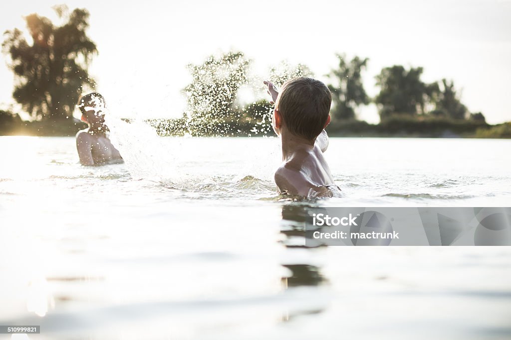 Boys having fun in a lake Swimming Pool Stock Photo