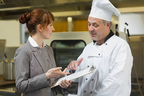Young female manager talking to the head cook
