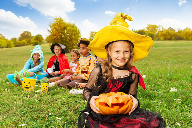 istock Nice girl in witch costume holds carved pumpkin 511000799