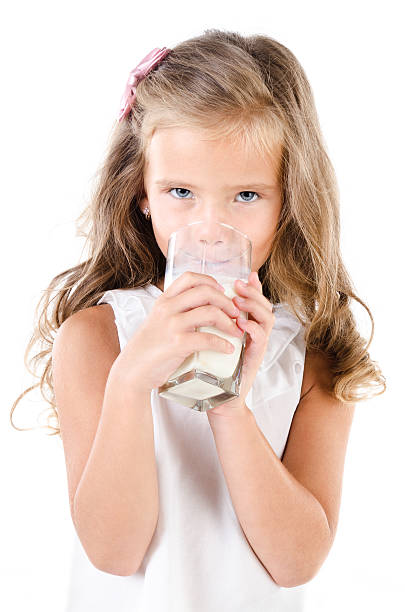 istock Smiling little girl drinking milk isolated 511002371