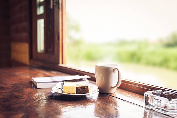 istock Cake and coffee cup on wooden table near window sill. 511009854