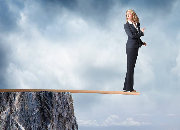 istock Businesswoman Looks Behind Her As She Walks Plank 511014354