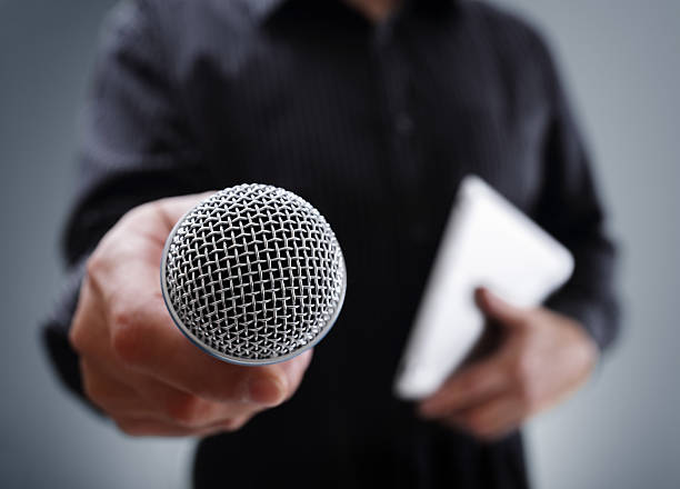 Interview with microphone Hand holding a microphone conducting a business interview or press conference tv reporter photos stock pictures, royalty-free photos & images