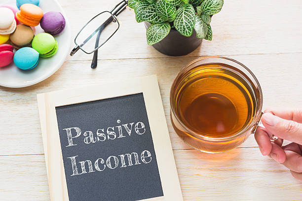 Concept Passive Income message on wood boards. Concept Passive Income message on wood boards. Macaroons and glass Tea on table. Vintage tone. multi level marketing stock pictures, royalty-free photos & images