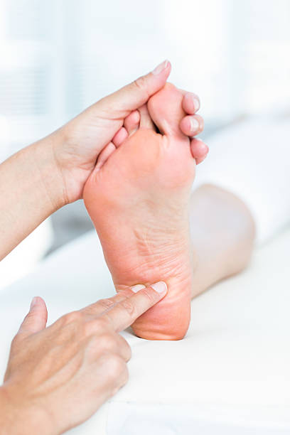 istock Physiotherapist massaging her patients foot 511015602