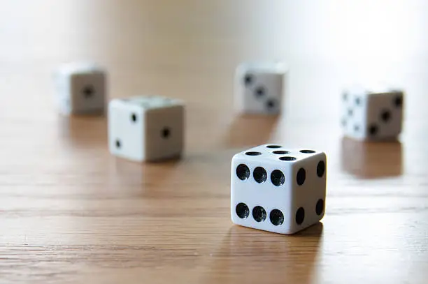 Five dice lying on a table.
