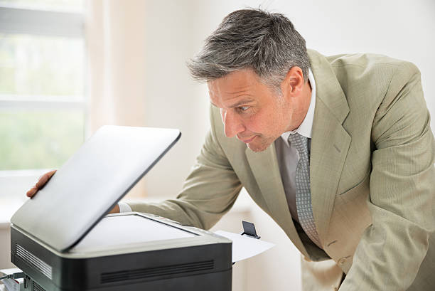 istock Businessman Looking At Photocopy Machine 511018916