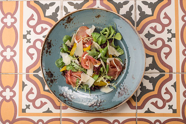 Salad with cured ham, fresh vegetables and parmesan cheese stock photo