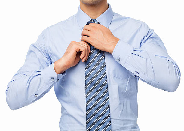 Management, close-up of green tie on lilac button down shirt against purple background. Focused on tie. 
