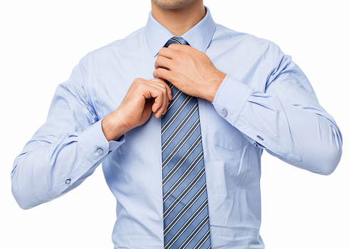 Midsection of businessman adjusting tie isolated over white background. Horizontal shot.