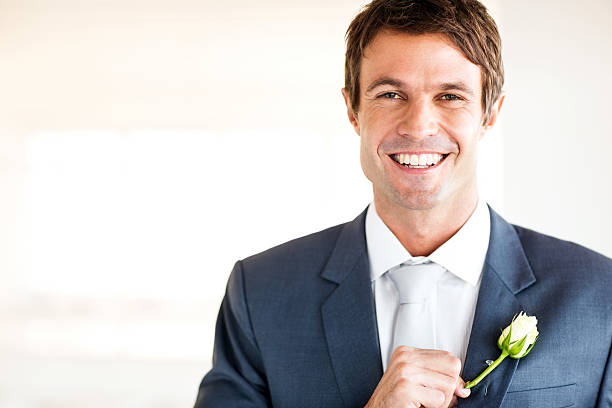 istock Groom Pinning Boutonniere On Suit 511021456