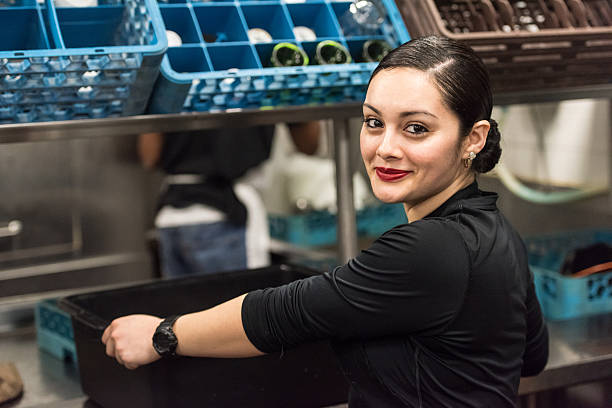 Young hispanic female kitchen worker Smiling Young hispanic female kitchen worker looking at the camera immigrant stock pictures, royalty-free photos & images