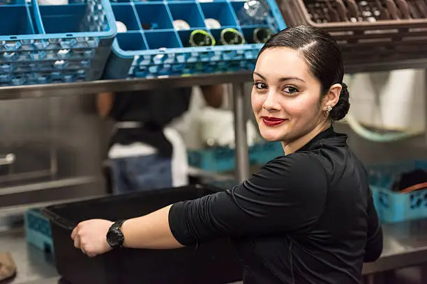 Smiling Young hispanic female kitchen worker looking at the camera