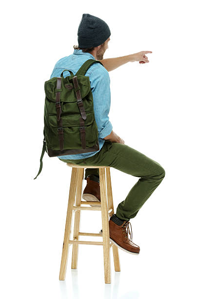 istock Rear view of hipster on stool and pointing 511022028