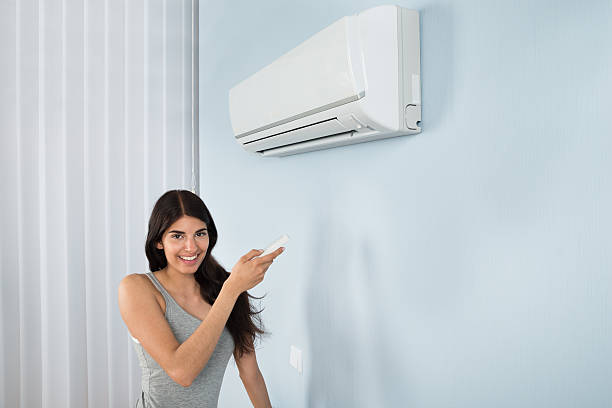 istock Woman Holding Remote Control Air Conditioner 511024822