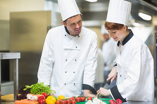 istock Female chef slicing vegetables with colleague 511024831