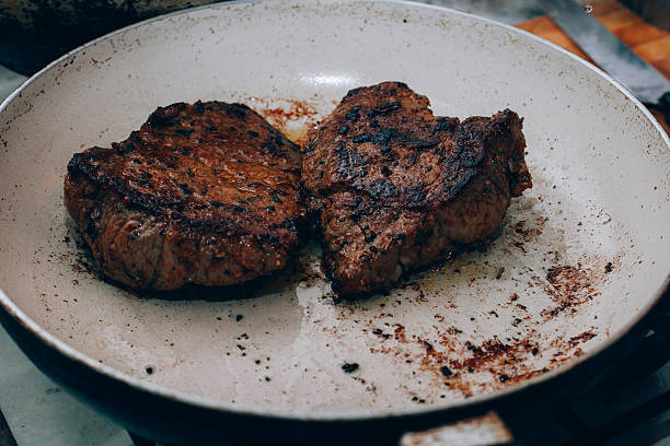 demasiado de carne de vacuno se encuentran en blanco sartén - strip steak steak barbecue grill cooked fotografías e imágenes de stock