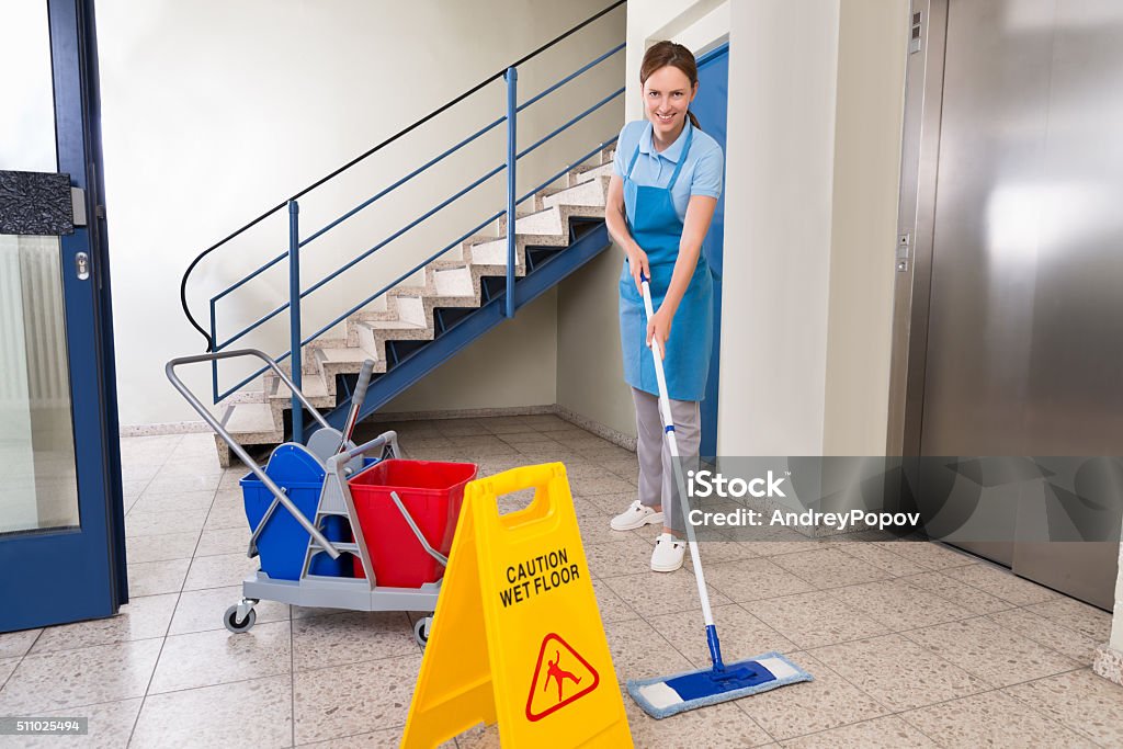 Arbeiter mit Reinigung Ausstattung und Wet Floor Sign - Lizenzfrei Reinigen Stock-Foto