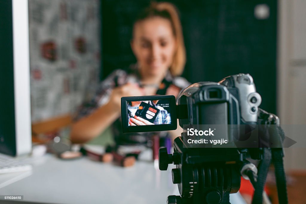 Teenage girl Making Her Video Blog. Smiling Teenage girl making her video blog about makeup. She is using home video camera to record video blogs and publish online. Selective focus to camera screen. She is blogger and vlogger. 14-15 Years Stock Photo