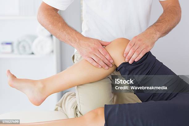 Physiotherapist Controlling Knee Of A Patient Stock Photo - Download Image Now - 20-29 Years, 25-29 Years, 30-34 Years