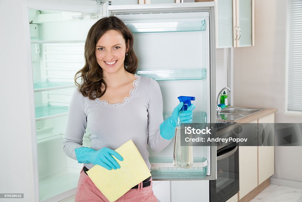 Woman With Rag And Spray Bottle Near The Fridge Young Beautiful Woman Standing With Rag And Spray Bottle Near The Open Fridge Adult Stock Photo