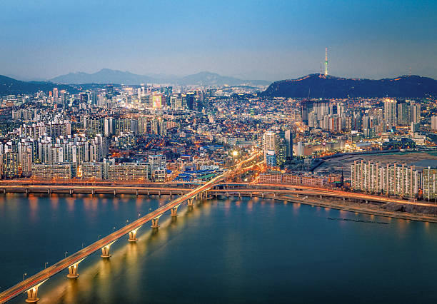 Seoul seen across the River Han from the Gangnam side, with N Seoul Tower on top of Namsan Mountain in the distance, on the horizon.
