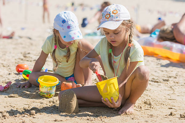 istock Two girls playing in the sand on the beach 511030694