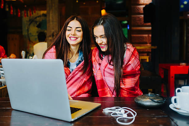 istock two girls watching something in laptop 511032576