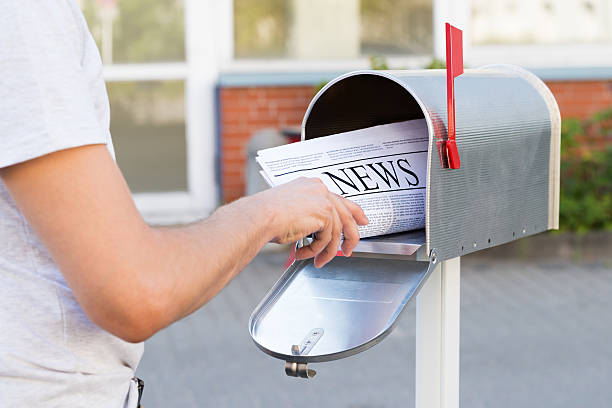 istock Person Hands Opening Mailbox To Remove Newspaper 511051614