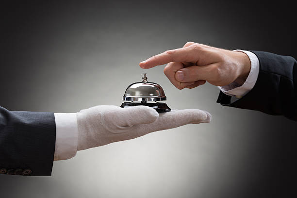 Close-up Of A Person's Hand Ringing Service Bell Close-up Of A Person's Hand Ringing Service Bell Hold By Waiter hotel occupation concierge bell service stock pictures, royalty-free photos & images