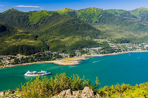 Entering Juneau Harbor A luxury cruise ship sails  along a narrow straight to reach Juneau, Alaska. on an August morning. juneau stock pictures, royalty-free photos & images