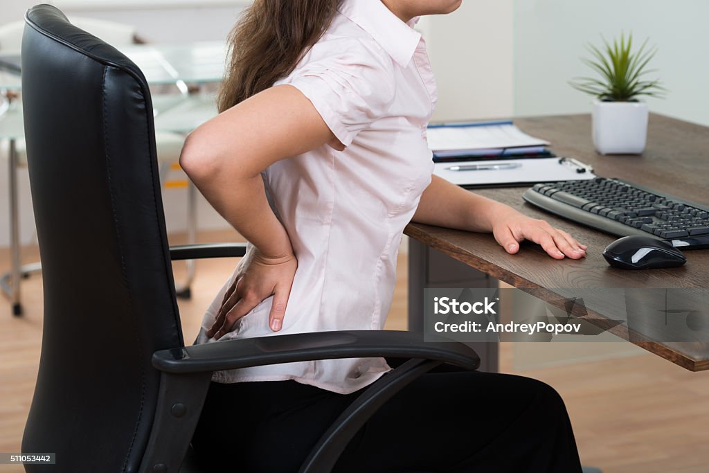 Businesswoman Having Backpain Close-up Of Young Businesswoman On Chair Having Backpain In Office Office Chair Stock Photo