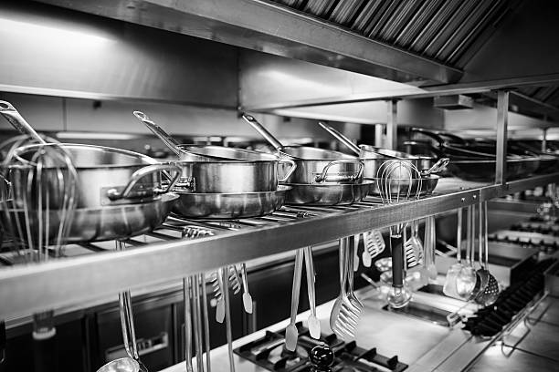 industrielle küche mit töpfen und werkzeuge auf den regalen - flatware silverware in a row eating utensil stock-fotos und bilder