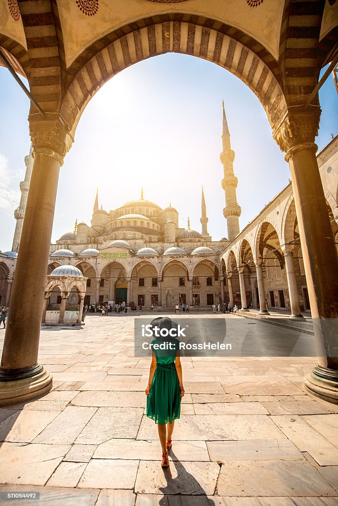 Woman near the Blue Mosque in Istanbul Young woman traveler in the green dress and hat walking to the Blue Mosque in Istanbul Istanbul Stock Photo