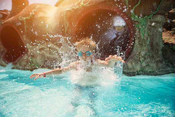 istock Little boy having fun sliding in water park 511056330