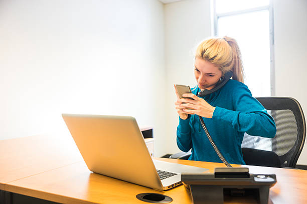 istock Young woman at her desk in an office multi-tasking. 511057400