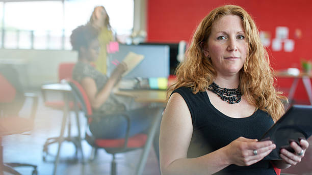 istock Confident female designer working on a digital tablet in red 511058096