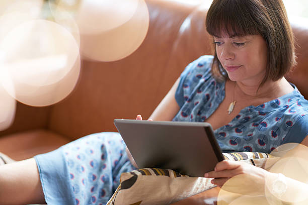 istock Mature woman browsing the internet on a digital tablet 511058426