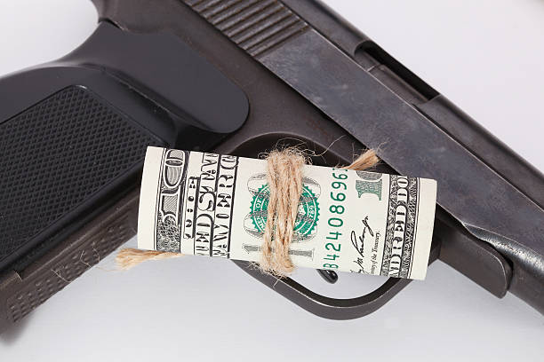 istock Black gun is lying on dollar bills 511058936