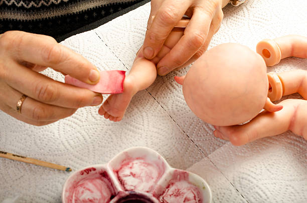istock Hand painted reborn dolls. Application of lacquer on foot. 511059136