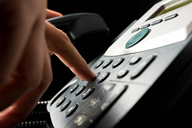 istock Person dialing out on a landline telephone 511060667