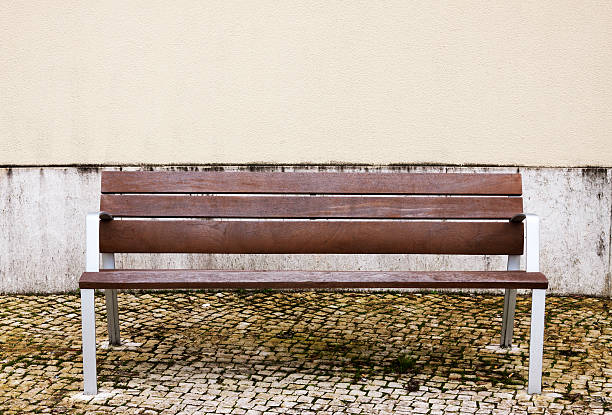 istock City bench and pale yellow wall 511061072