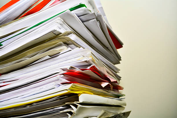Stack of files on his desk Stack of files on his desk legal defense photos stock pictures, royalty-free photos & images