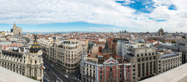 Panorama view of Gran Vía and Madrid's skyline on a cloudy Spring early morning, with the Metropolis building to be recognized in the foreground. Some other landmarks like the Telefonica skyscraper, Faro de Moncloa, Colon Tower or AZCA skyscrapers are also to be recognised.