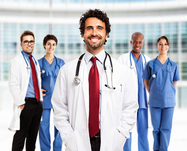 istock Smiling doctor in front of his team 511062411