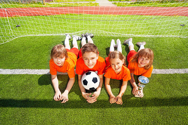 istock Smiling children lay on grass with golden goblet 511062597